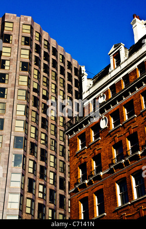 Una chiusura immagine di due edifici con colori contrastanti che li rende si stagliano contro il cielo blu. Foto Stock