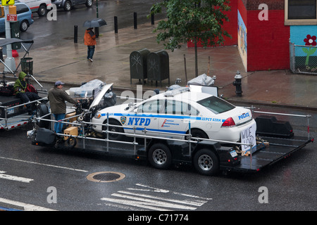 Una produzione equipaggio spara un NYPD auto della polizia su un rimorchio durante un tiro nel traffico, Foto Stock