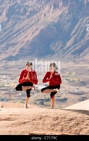L uomo e la donna che colpiscono un yoga posa in Moab, Utah. Foto Stock