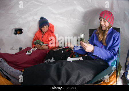 Un ragazzo e una ragazza a giocare a carte nella grotta di neve, Silverton, Colorado. Foto Stock