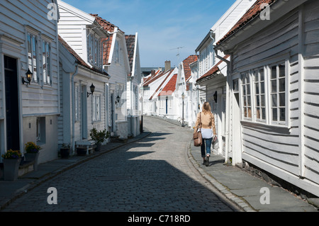 Una ragazza a piedi attraverso i vicoli della vecchia area di Stavanger, Norvegia Foto Stock