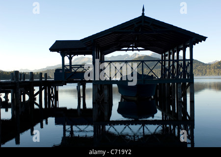 La calma perfetta all'alba annunciando un giorno di inimitabile meteo. Un capannone in barca sul Lago Nahuel Huapi, Argentina. Foto Stock