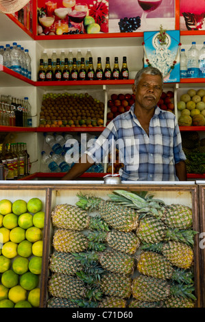 I dipendenti di un succo di frutta fresca in stallo per le strade di Madurai, Tamil Nadu, India. Foto Stock