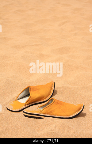Marocchino tradizionale pantofola-scarpe (babouches) di sabbia su una spiaggia marocchino con copia spazio, Marocco, Africa del Nord Foto Stock