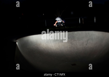 Un felice uomo atletico di skateboard di notte in Idaho. Foto Stock