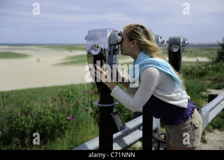 Una giovane donna bionda si affaccia al mare. Foto Stock