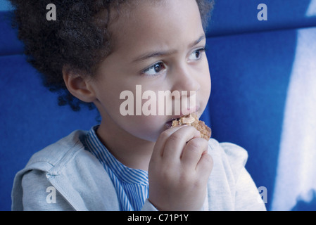 Bambina mangiare cookie, ritratto Foto Stock