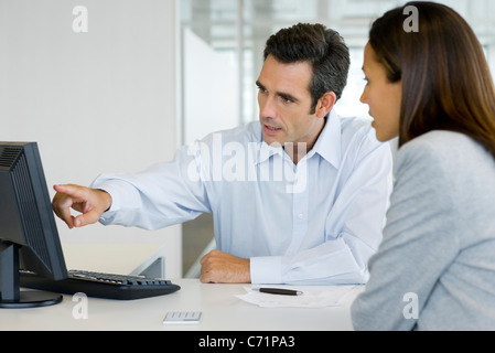 Advisor finanziario per spiegare al cliente i dati sul computer desktop Foto Stock