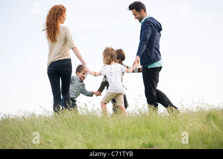 Famiglia la riproduzione ad anello attorno al Rosy in Prato Foto Stock