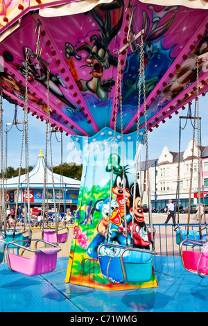 Vivacemente colorato sedia-o-piano fairground ride, rotonda o giostra di oscillazione a Barry Island in Galles, Regno Unito Foto Stock