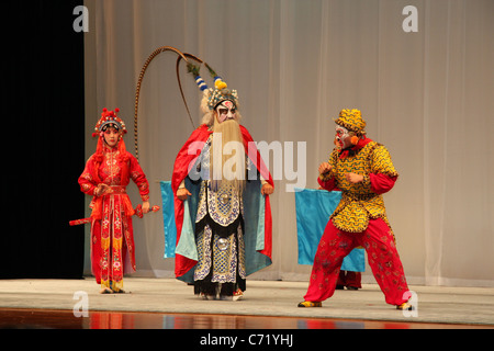 Tre musicisti in costumi colorati eseguire sul palco dell'Opera di Pechino a Pechino, Cina. Foto Stock