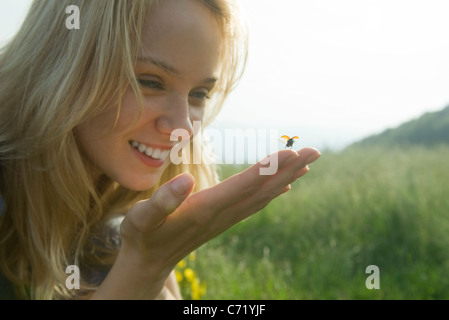 Giovane donna holding coccinella come si decolla in volo Foto Stock