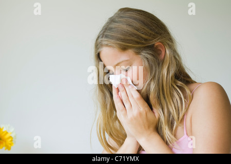 Giovane donna soffia il naso Foto Stock