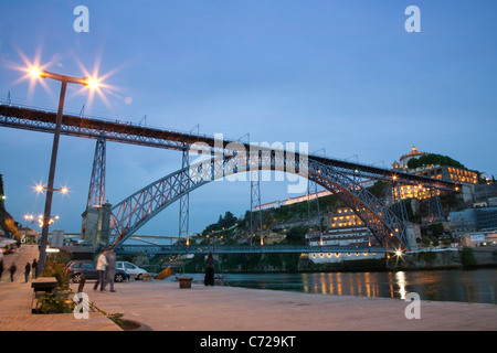 Porto - twilight dal Fiume Douro, Ponte Dom Luis, bridge da Eiffel con monastero illuminato in background Foto Stock