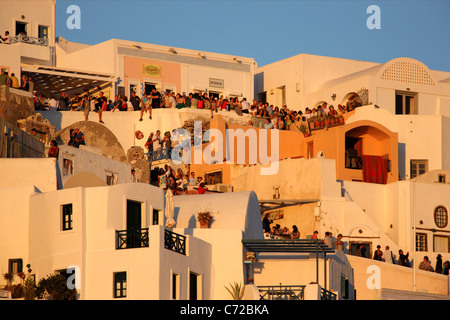 Centinaia di 'sunset dei cacciatori sono raccolti ogni sera a terrazze e vicoli di Oia per godere il suo famoso tramonto. Santorini Foto Stock