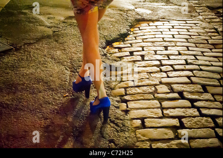 Fashionistas manovrare le strade di ciottoli nel loro tacchi alti scarpe nel trendy Meatpacking District di New York Foto Stock