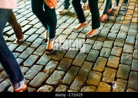 Fashionistas manovrare le strade lastricate in loro designer di calzature nel trendy Meatpacking District di New York Foto Stock