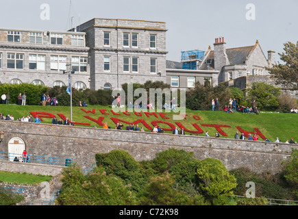 Plymouth waterfront e zappa con un benvenuto a Plymouth segno fatto di fiori in un letto di fiori. Foto Stock