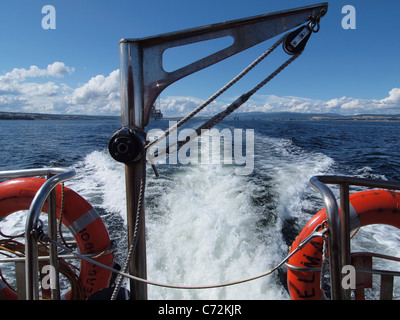 Guardando indietro per impianti di trivellazione del petrolio ormeggiato per invergordon in Cromarty Firth da una barca pilota Foto Stock