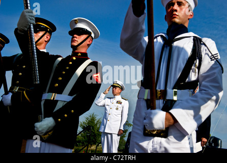 Stati Uniti Navy Adm. Mike Mullen, presidente del Comune di capi di Stato Maggiore rende onori durante la riproduzione di un inno nazionale. Foto Stock