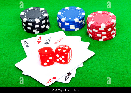 Vincere la mano di poker di 4 assi giocando a carte e dadi rossi su sfondo verde Foto Stock