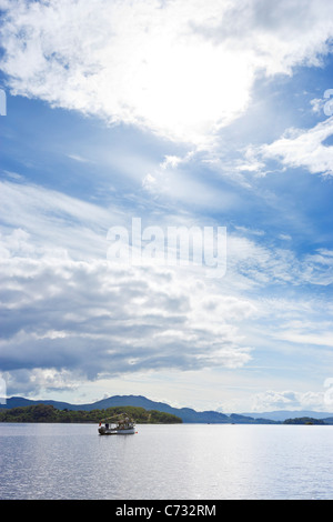 Barca da pesca sul loch visto da Luss sulla sponda occidentale del Loch Lomond, Argyll and Bute, Scotland, Regno Unito Foto Stock