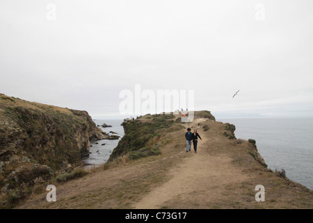 La gente che camminava su un sentiero su una scogliera al punto Reyes, California. Foto Stock