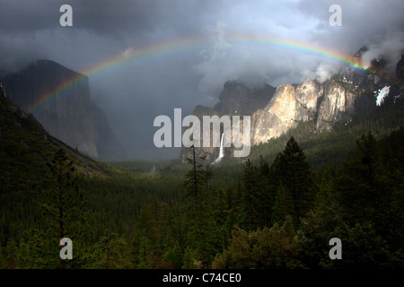 Un bellissimo arcobaleno appare sopra la valle di Yosemite in seguito ad una tempesta di pioggia. Foto Stock