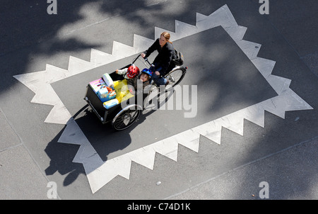 Una donna con due bambini su un cargo bike Foto Stock