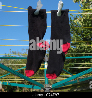 Un paio di calzini Mens essiccazione su una linea di lavaggio Foto Stock