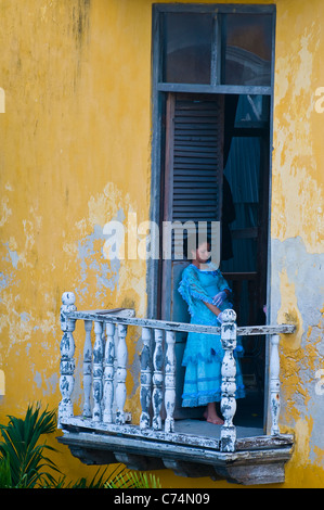 La ragazza di un balcone in una vecchia casa Foto Stock