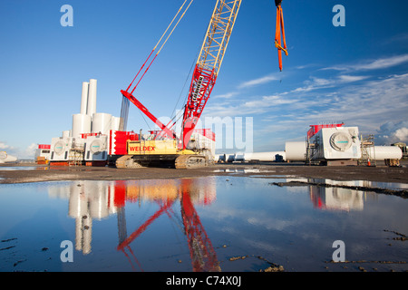 Turbina eolica le parti destinate alla Walneyoffshore wind farm, che si riflette in una pozzanghera sulla banchina a Mostyn. Foto Stock