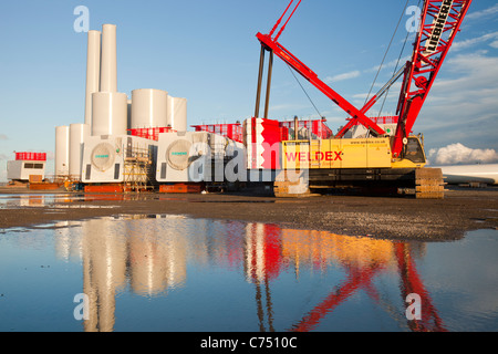 Turbina eolica le parti destinate alla Walneyoffshore wind farm, che si riflette in una pozzanghera sulla banchina a Mostyn. Foto Stock