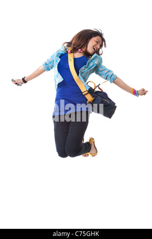 Bella donna college jumping mentre si ascolta la musica su sfondo bianco Foto Stock
