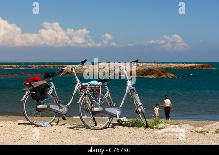 Due biciclette parcheggiate presso le rive del Mediterraneo vicino a Saintes Maries de la Mer, Francia Foto Stock