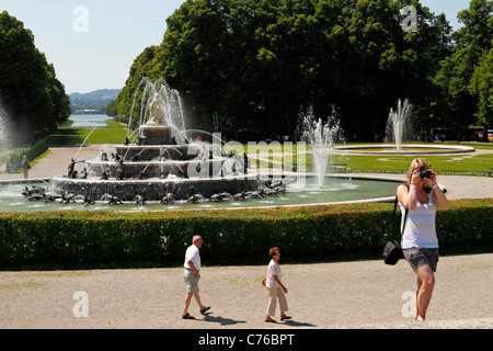 Donna di scattare una foto di fronte alla Fontana di Latona, Herrenchiemsee Herreninsel Alta Baviera Germania Foto Stock