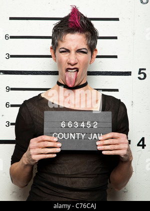 Studio mugshot di donna matura spuntavano lingua Foto Stock