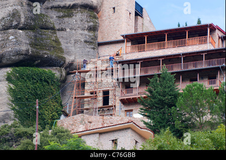 Operai della costruzione su una impalcatura, rinnovando il monastero Roussanou nel Meteoras, Grecia. Foto Stock