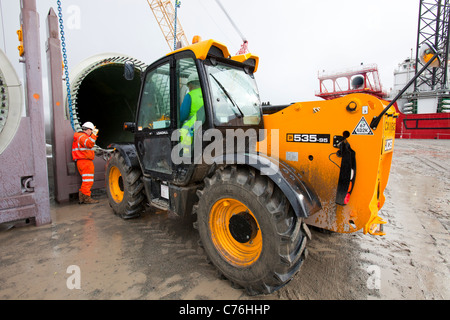 Preparare i lavoratori per il sollevamento di una turbina eolica sulla lama di un jack up barge per il Walney offshore wind farm, Cumbria, Regno Unito. Foto Stock