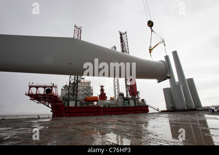 Pale per turbine eoliche sollevato su un martinetto fino chiatta, per costruire il Wlaney offshore wind farm. Foto Stock