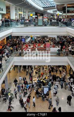 Vista dall'alto guardando verso il basso la folla affollata di persone nei centri commerciali a tre piani interni di Stratford City Westfield, East London, Inghilterra, Regno Unito Foto Stock