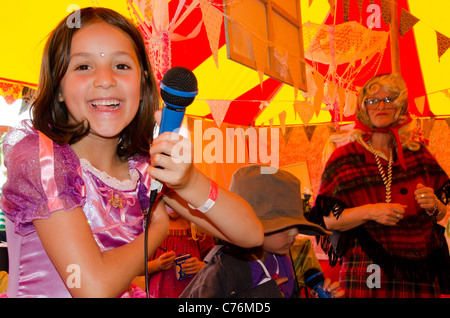 Giovane ragazza in costume di fronte alla fotocamera tenendo un microfono al lo Shambala Festival 2011 Foto Stock