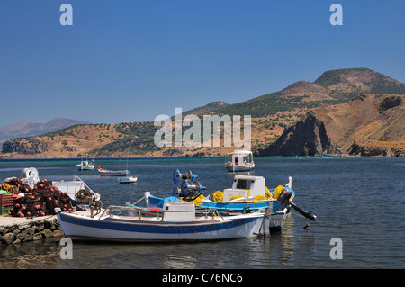 Barche da pesca e reti nella riparata baia naturale di Kalo Limani, isola di Lesbo (Lesbo), in Grecia, in agosto. Foto Stock