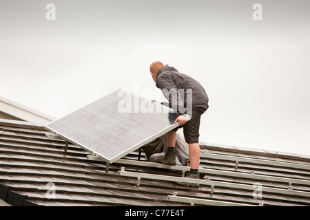 Lavoratori un raccordo 4 Kw sistema di pannelli solari per una casa tetto in ambleside, cumbria, Regno Unito. Foto Stock