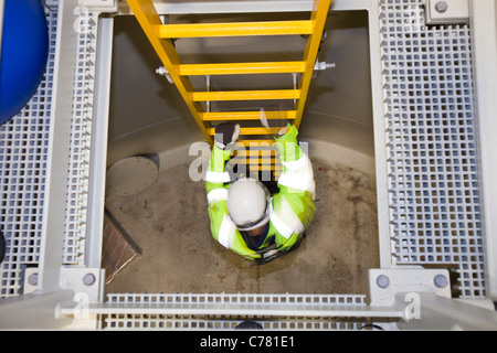 Un ingegnere scende nella base di un pezzo di transizione su una turbina eolica all'Walney offshore wind farm. Foto Stock