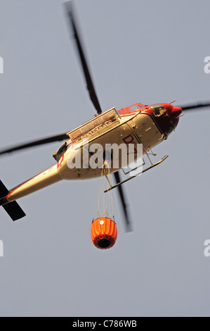 Bell 412 elicottero (registrazione N167EH) prendere acqua a pennello fire, Cabopino Golf, Costa del Sol, Andalusia, l'Europa. Foto Stock