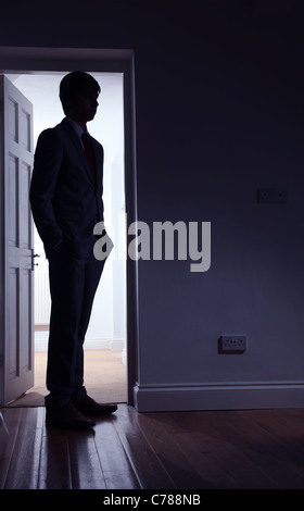 Silhouette di un uomo in piedi di fronte a una porta aperta. Foto Stock