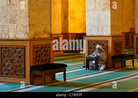 L'uomo la lettura del Corano dentro la grande moschea di Aleppo, Siria Foto Stock