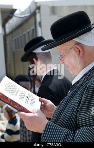 Hasidic Ortodosso Ebrei pregare durante la combustione la cerimonia chametz in Mea Shearim quartiere di Gerusalemme. Foto Stock