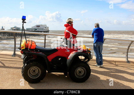 Blackpool Beach Patrol ansiosamente parlando a un uomo depresso sul lungomare durante una burrasca Foto Stock